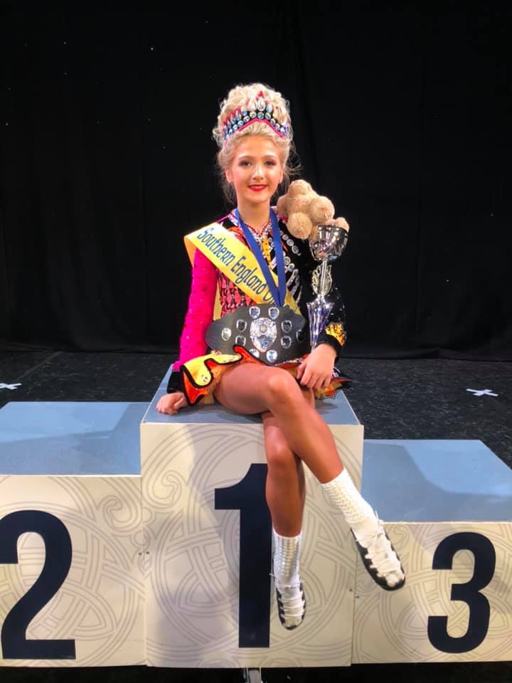 A Céim Óir dancer on the top step of the podium with her trophies